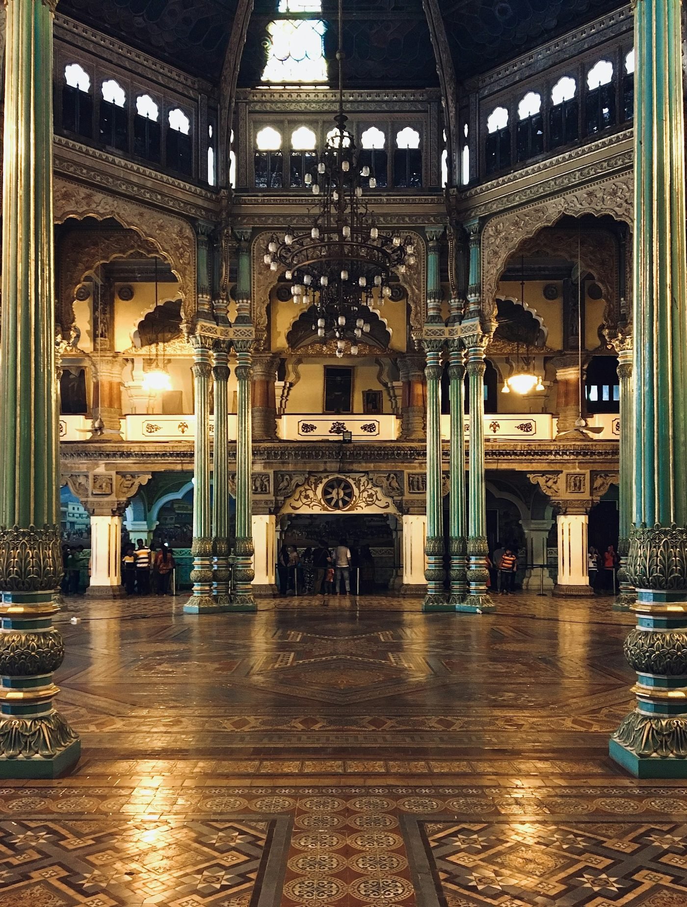 An ornate palace interior with columns and chandeliers