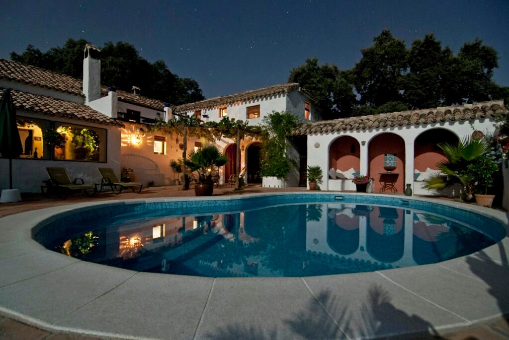 Illuminated villa with a courtyard swimming pool at night